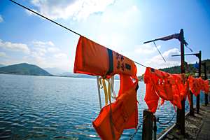 Personal flotation devices hang to dry on a line on pier.