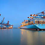 Cargo ship moored at a container terminal in the Port of Hamburg, Germany, at dawn.